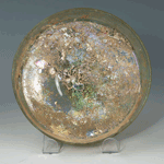 A Roman green glass shallow dish with omphalos, ca 2nd - 3rd century AD